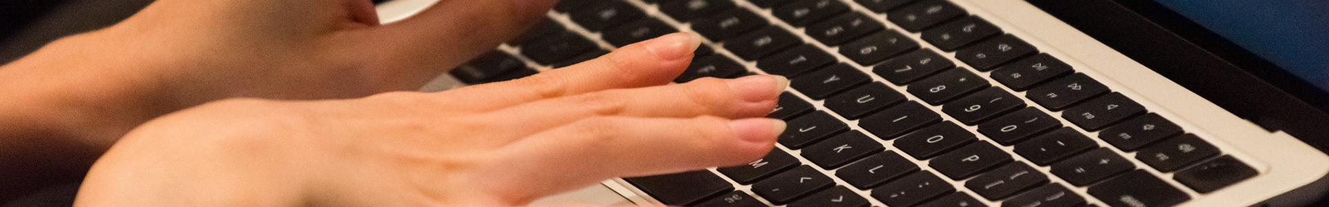 Fingers typing on a laptop keyboard