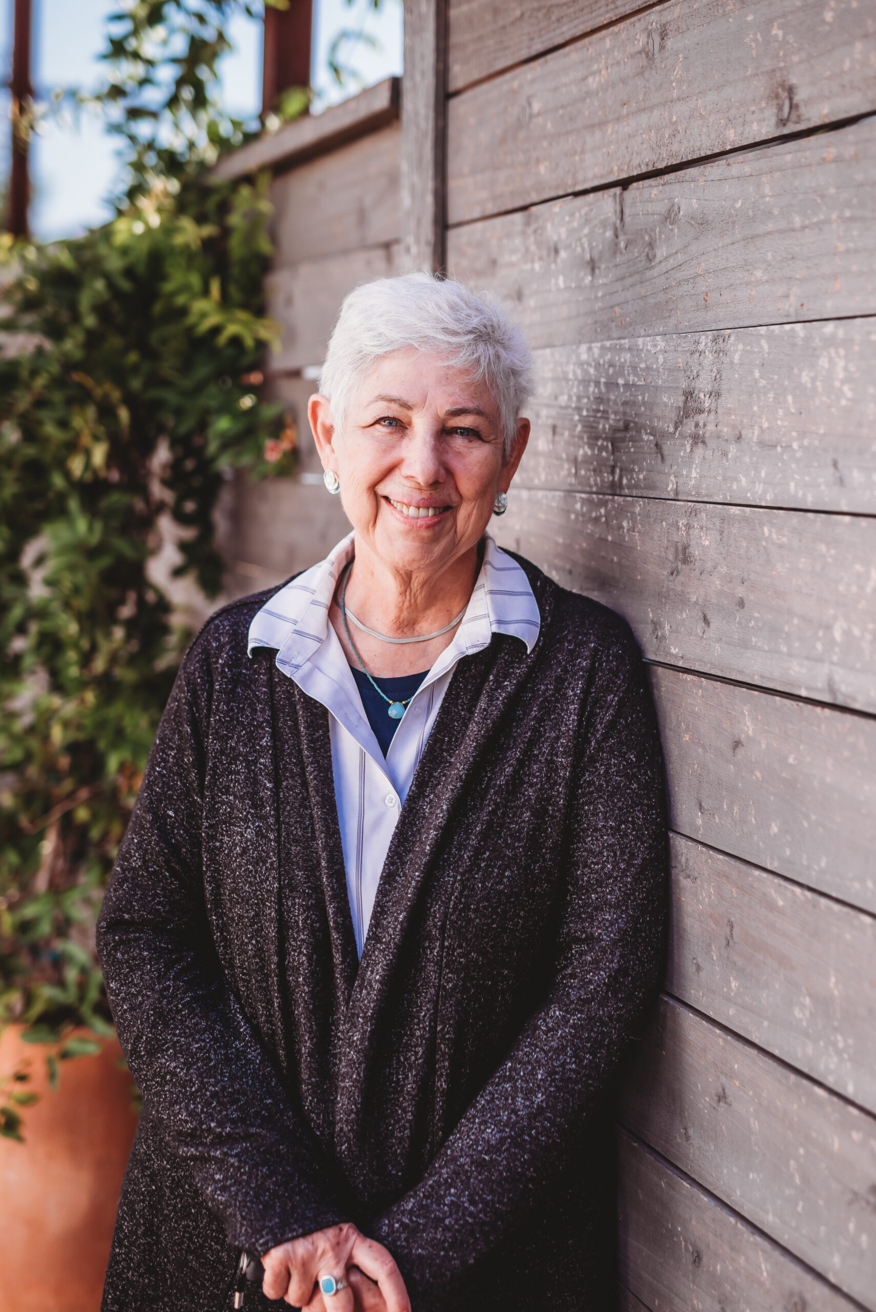 An older woman with silver hair and Scottish complexion, smiling, wearing a dark heather jacket and a striped shirt.