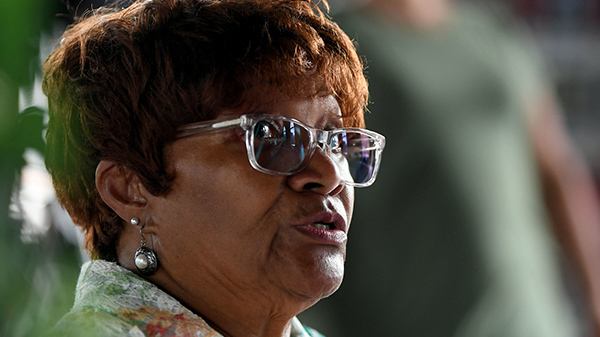 Woman wearing glasses talking to someone out of frame