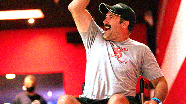 Man who uses a wheelchair celebrating by pumping his arm in the air