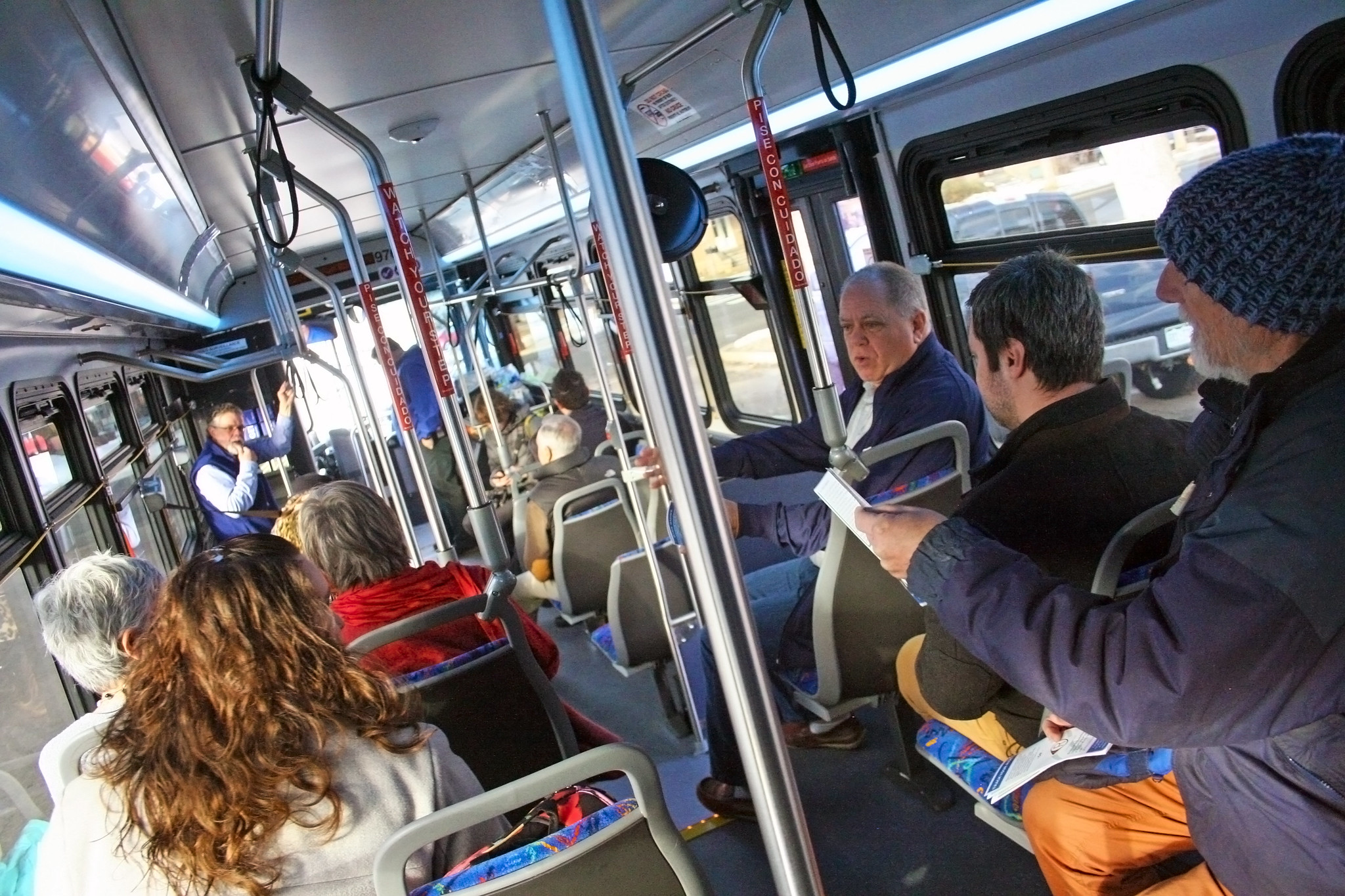 Adults riding a city bus together.