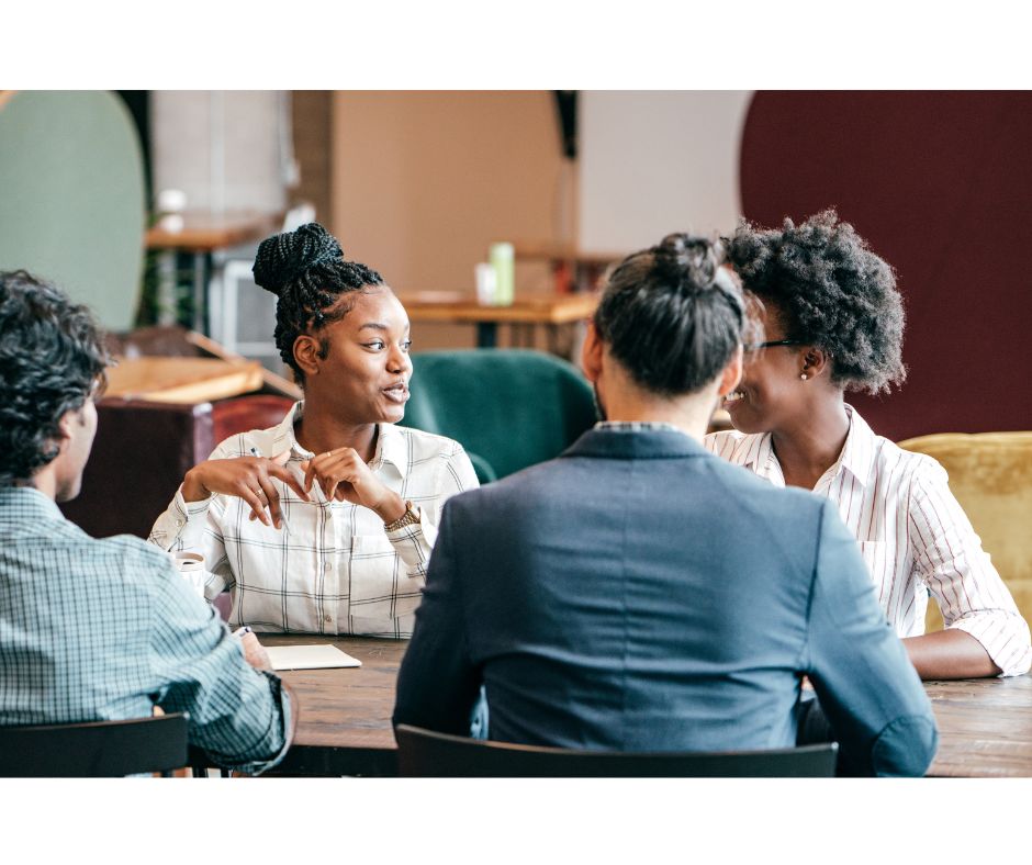 A group of people talking at a table.