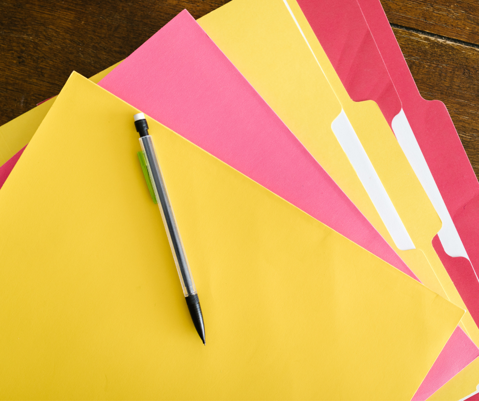 Colorful file folders with a pen on top.
